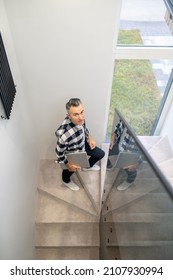 Man With Laptop Climbing Stairs Looking At Camera