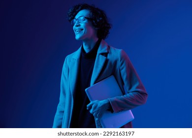 man with a laptop in his hands and a jacket, a smile, futuristic glasses in blue light, Blue Perennial color, cyber security, technology, laptop copy space, trend neon, freelance work, neon light