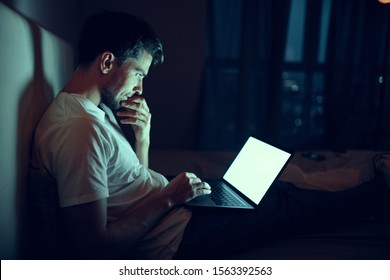 Man laptop internet night dark bed sleep - Shutterstock ID 1563392563