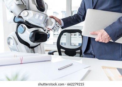 Man with laptop is shaking hands with android - Powered by Shutterstock