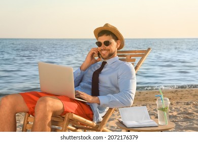 Man With Laptop Talking By Mobile Phone On Beach. Business Trip