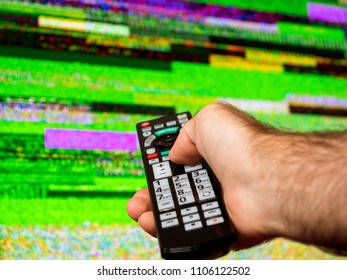 Man with large tv remote trying to fix the digital television noise on a large plasma OLED 4K Ultra HD High Dynamic Range HDR Smart TV . - Powered by Shutterstock