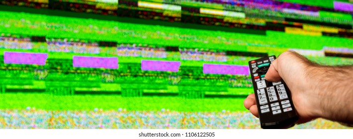 Man with large tv remote trying to fix the digital television noise on a large plasma OLED 4K Ultra HD High Dynamic Range HDR Smart TV . - Powered by Shutterstock