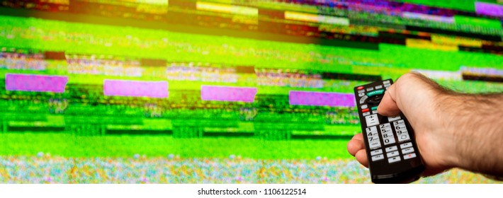 Man with large tv remote trying to fix the digital television noise on a large plasma OLED 4K Ultra HD High Dynamic Range HDR Smart TV flare - Powered by Shutterstock