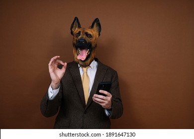 A Man With A Latex Dog Head Mask And A Smartphone