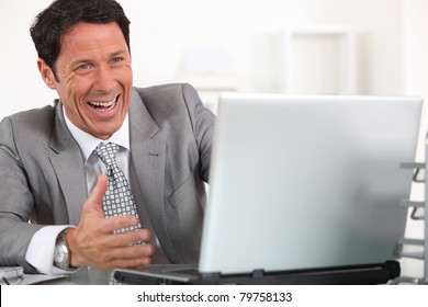 Man Laughing Hysterically At His Laptop Computer