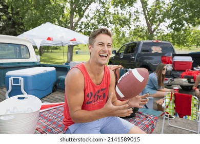 Man laughing at tailgate barbecue in field - Powered by Shutterstock