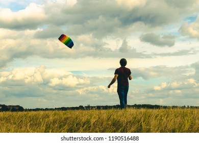 A man launches a kite against the cloudy sky. - Shutterstock ID 1190516488