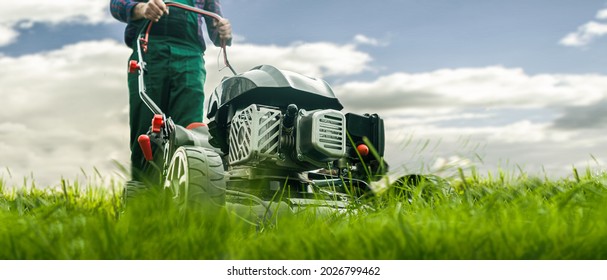 Man with lawn mower mowing the lawn
				
