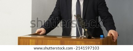 A man - a lawyer, politician, businessman or official speaks, leaning his hands on a podium or pulpit. Official statement. Orator, speaker or interviewee. No face