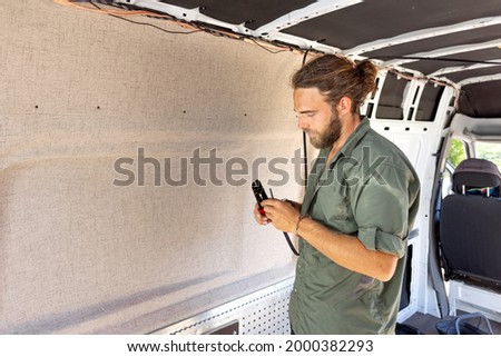 Man laying cables inside a camper van