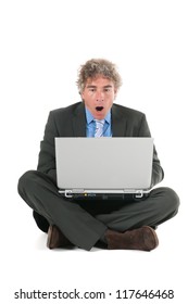 Man laying at the floor while working with laptop