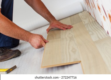 Man Laying Laminate Flooring In A Home.
