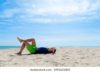 Man Laying On His Back On Beach.