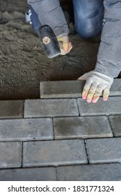 Man Laying Paving Stones On The Floor Using A Rubber Mallet. Vertical