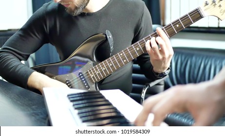 Man Lead Guitarist Playing Electrical Guitar. Rock Band Practice Play Piano. Musician Hands Playing On Electric Piano With Guitar Player. Music Band Concert