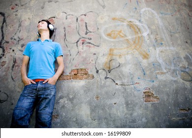 Man leaning against wall with graffiti