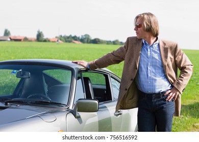 Man leaning on sports car - Shutterstock ID 756516592