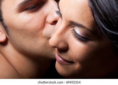 Man Leaning Over Kissing Woman On Cheek