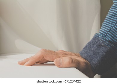 Man leaning and puts his hands down on white cloth background. - Shutterstock ID 671234422