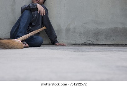 A man leans against the wall tired of cleaning the floor. - Shutterstock ID 751232572