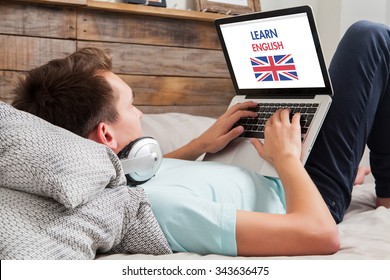 Man Learning English On The Internet With A Laptop Computer While Lies Down At Home