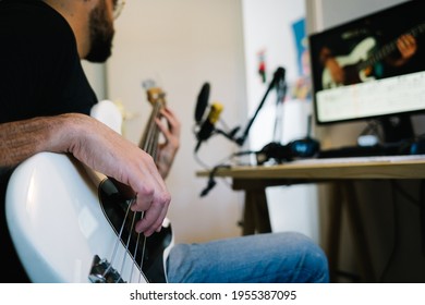 man learning how to play the bass doing an online class from home - Powered by Shutterstock