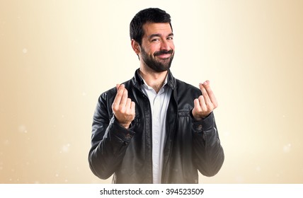 Man With Leather Jacket Doing A Money Gesture