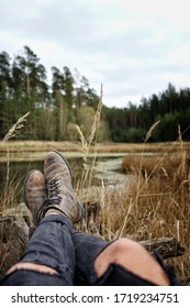 Man With Leatherboots And Ripped Black Jeans Chilling At A Lake In The Forest