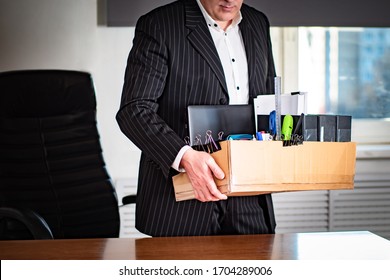 A Man Leaves The Workplace With A Cardboard Box In His Hands. Job Change. The Transition To Another Job. Dismissal. Changing The Type Of Activity. Search For The Best Features.