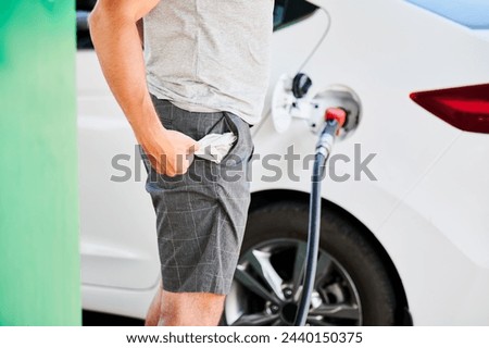Man left with empty pockets after spending all money on fuel. Cropped view of man showing that he has no money after refueling his car. High fuel prices concept.