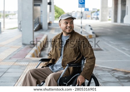 A man with a leg disability who cannot walk uses a wheelchair and travels by the train at a station He walks along the sidewalk where there are signs indicating accessibility for disabled individuals