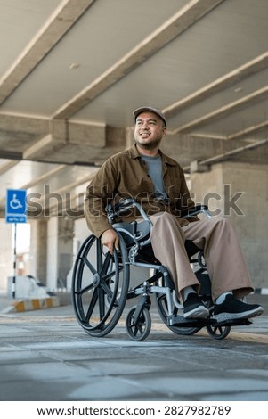 A man with a leg disability who cannot walk uses a wheelchair and travels by the train at a station He walks along the sidewalk where there are signs indicating accessibility for disabled individuals