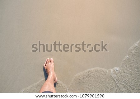 Man leg on the sand beach and sea, Top view