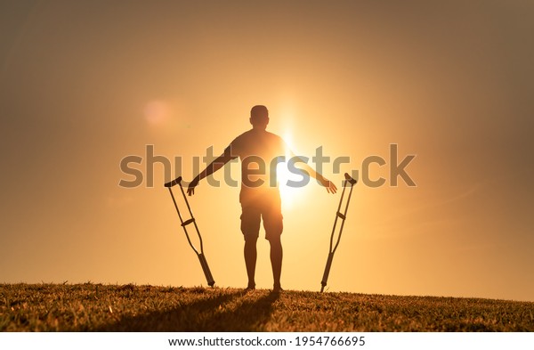 Man letting go of crutches able to\
walk again. Body recovery, healing, and miracle concept.\
