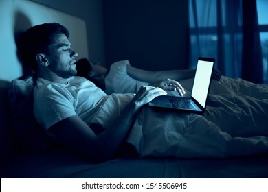 A Man Lies In Bed Open Laptop Night Watching Internet Movies