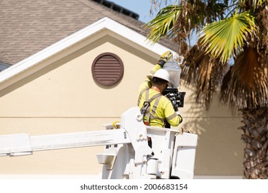 Man In A Lift Bucket, Replacing A Street Light In A Florida Neighborhood