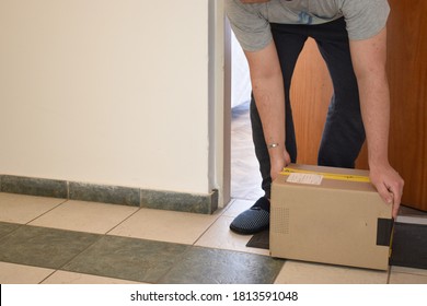 man lifting a package at the door of his house