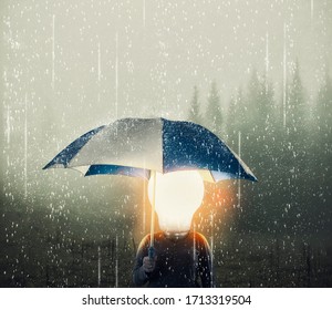 Man With A Lightbulb Instead Of Head Holding Umbrella While Raining .  Positive Mindset Concept.