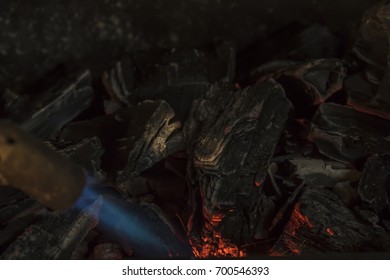 A Man IS Lighting Charcoal With Propane Torch On Home Made Grill Close Up