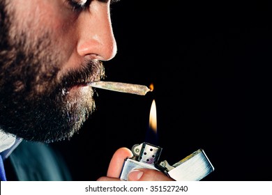 Man Lighting And Smoking A Joint