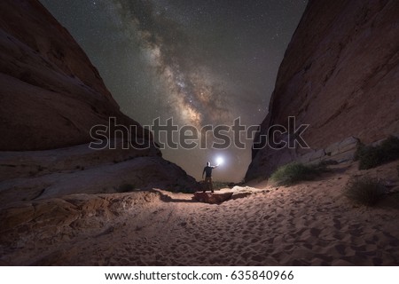 Man lighting up the White Domes in Nevada as the Milky Way Galaxy rises 