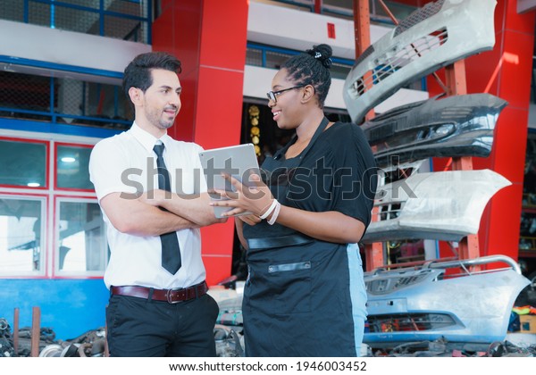 Man listen worker women in factory.\
Diversity of two people, caucasian business manager listen African\
worker woman said in\
factory-warehouse