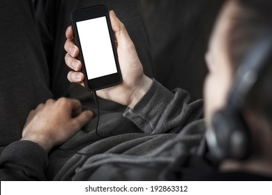 Man listening to the music and holding smart phone with blank screen.