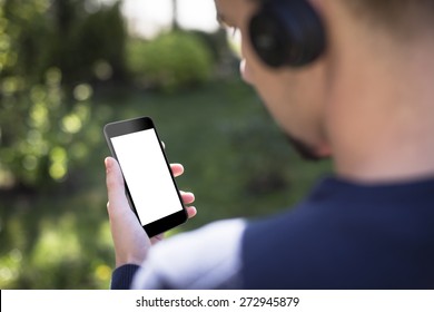 Man listening to the music and holding smart phone with blank screen, 
