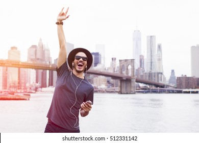 Man listening music with a rock sign hand up in Brooklyn, New York - Powered by Shutterstock