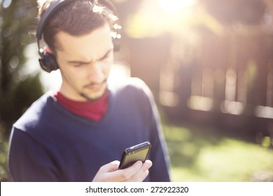 Man Listening To The Music From Smartphone With Wireless Bluetooth Technology. Focus On Smartphone