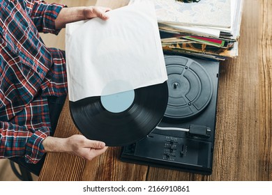 Man Listening To Music From Vinyl Record. Playing Music From Analog Disk On Turntable Player. Enjoying Music From Old Collection. Relaxing At Home. Retro And Vintage. Music Passion