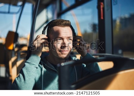 Man listening music in wireless headphones while commuting by public transportation. 
