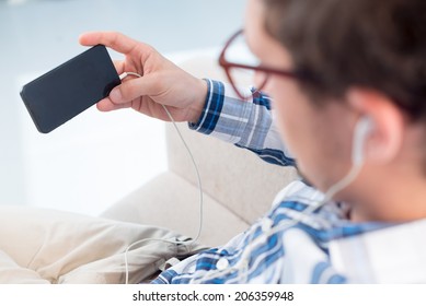 Man listening to the musing and holding smartphone